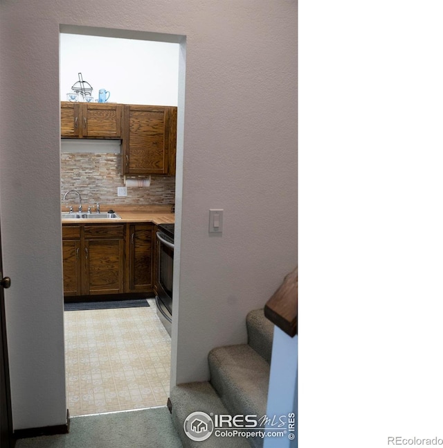 kitchen with sink, decorative backsplash, and stainless steel electric range