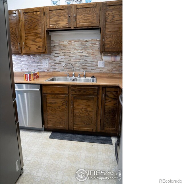 kitchen with stainless steel appliances, sink, and decorative backsplash