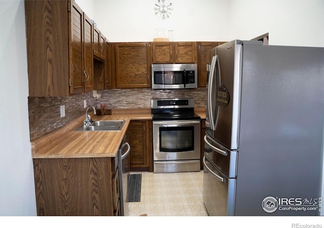 kitchen with stainless steel appliances, sink, and backsplash