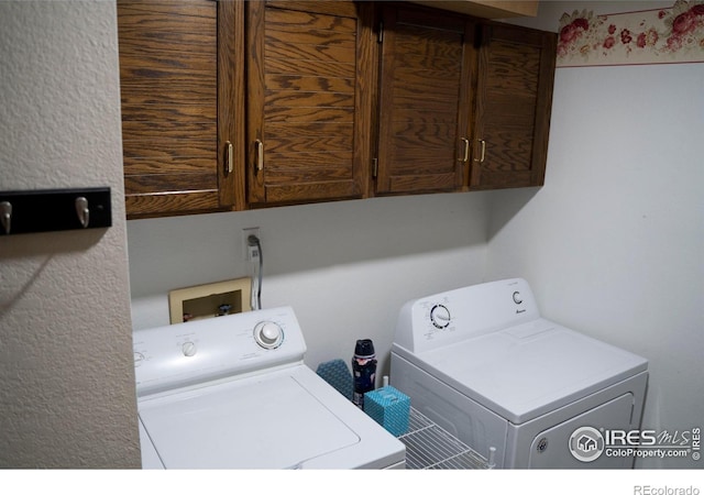 washroom with cabinets and washing machine and dryer