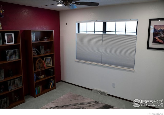 carpeted spare room with ceiling fan