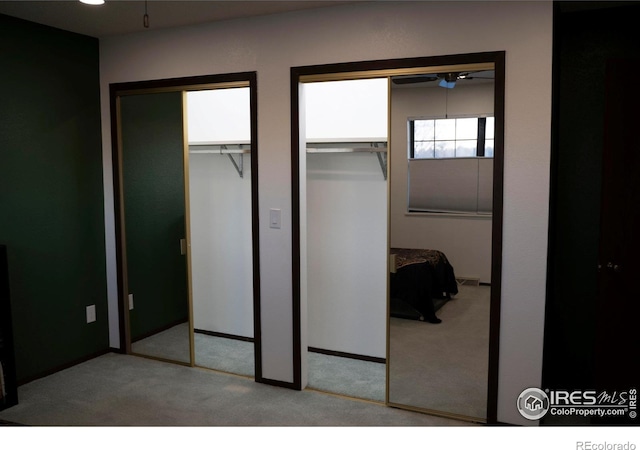 carpeted bedroom featuring multiple closets