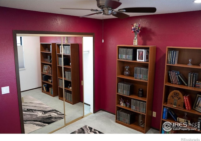 interior space featuring ceiling fan and light carpet