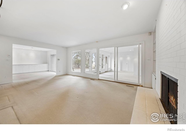 unfurnished living room with a fireplace and light carpet