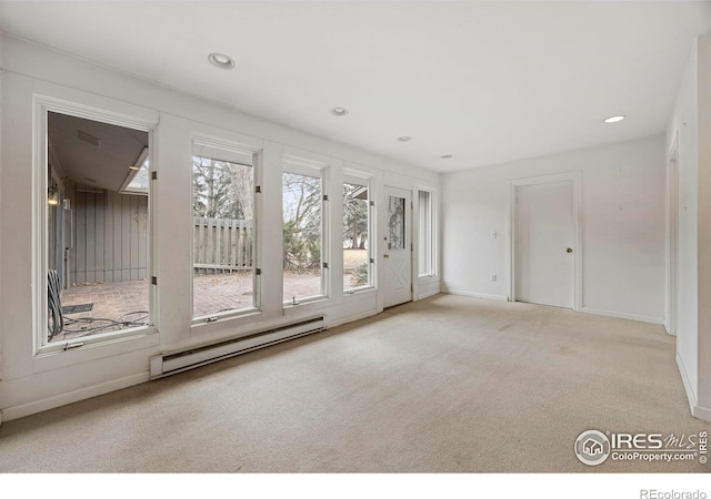 carpeted spare room featuring a baseboard heating unit