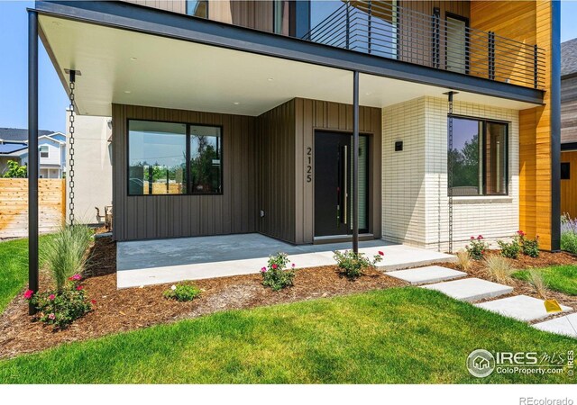 2125 Vine Ave, Boulder, CO 80304 - view of exterior entry featuring a porch, brick siding, and fence