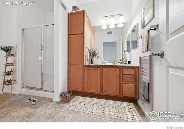 bathroom with vanity, radiator, tile patterned floors, and walk in shower