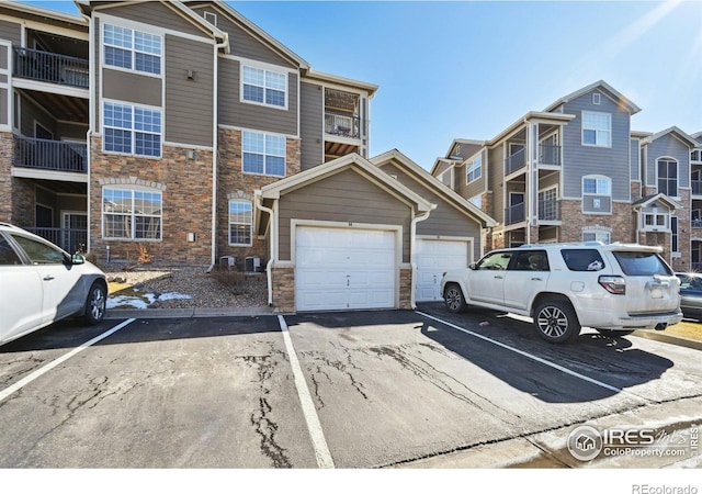 view of property featuring central AC unit and a garage