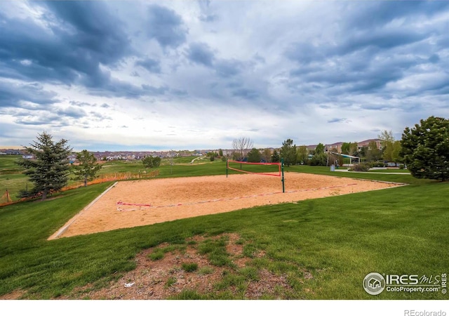 view of home's community featuring volleyball court and a lawn