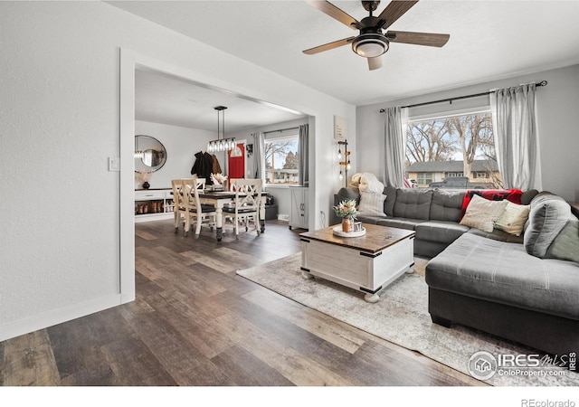 living room featuring ceiling fan, a healthy amount of sunlight, and dark hardwood / wood-style flooring