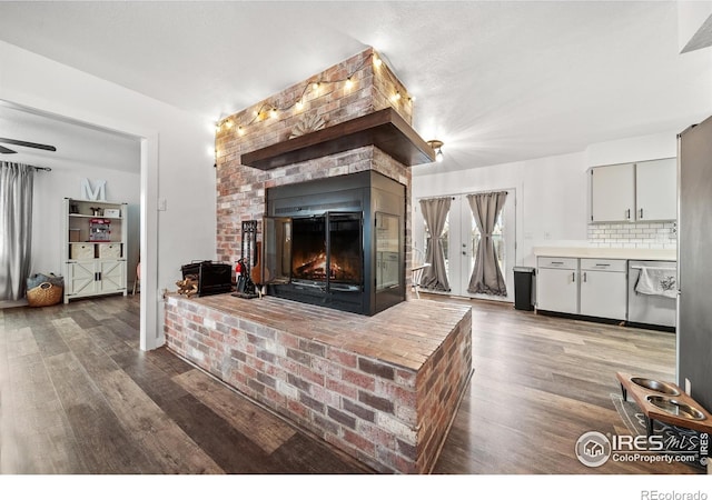 living room with dark wood-type flooring and a brick fireplace