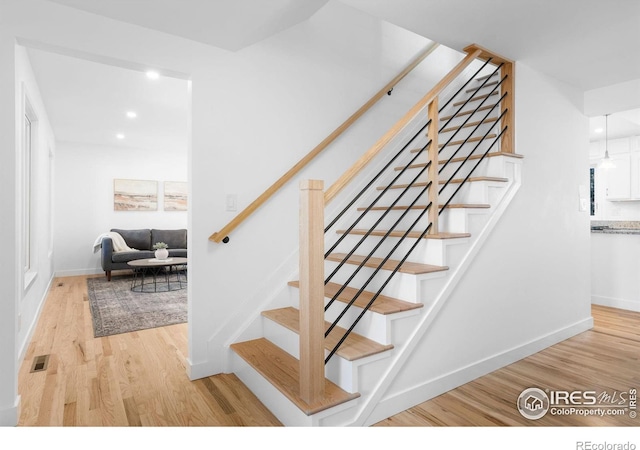 staircase with hardwood / wood-style floors