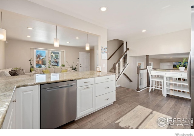 kitchen featuring white cabinetry, decorative light fixtures, light hardwood / wood-style flooring, dishwasher, and light stone countertops