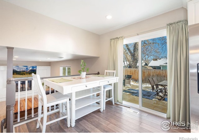 dining area featuring hardwood / wood-style flooring and decorative columns