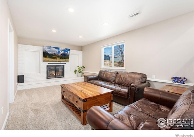 living room with a fireplace and light colored carpet