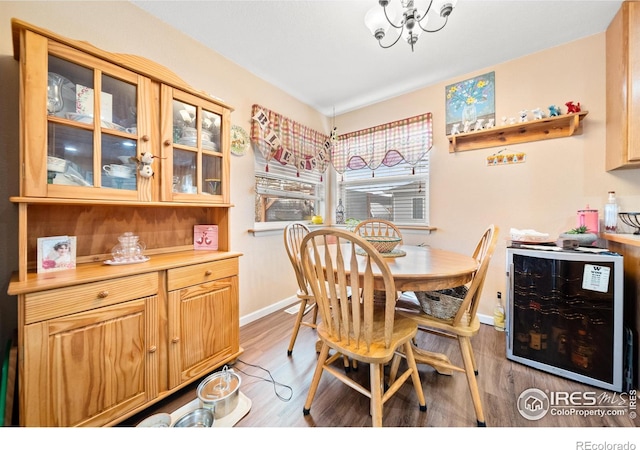 dining area featuring wine cooler, an inviting chandelier, and hardwood / wood-style floors