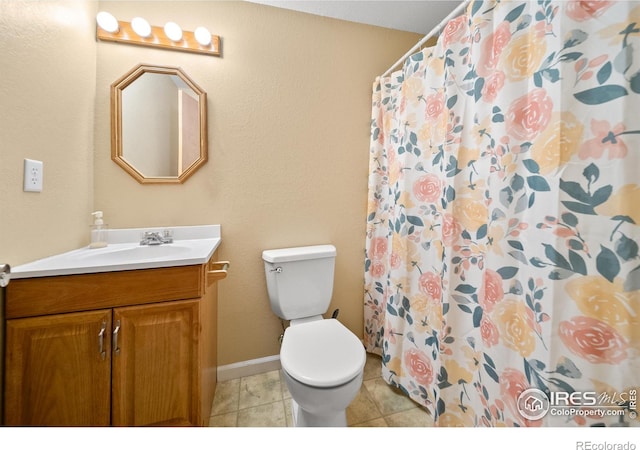 bathroom with tile patterned flooring, vanity, toilet, and walk in shower