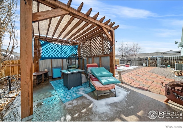 snow covered patio featuring central AC, a pergola, and a fire pit