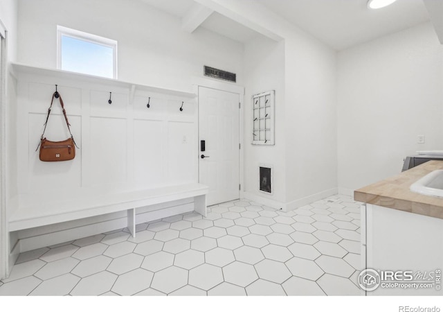 mudroom with beamed ceiling and sink