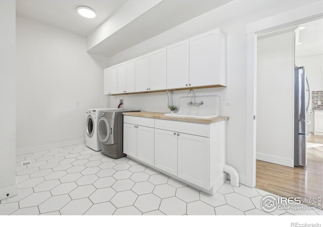 laundry area with cabinets, sink, and independent washer and dryer