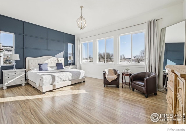 bedroom featuring a notable chandelier and light hardwood / wood-style flooring