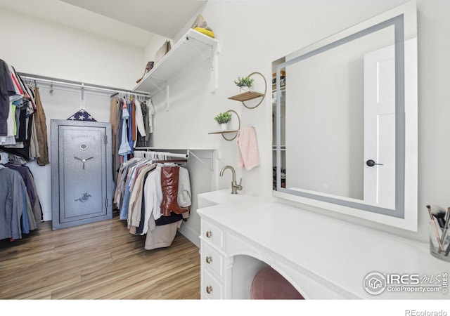 spacious closet featuring sink and light hardwood / wood-style floors