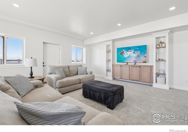 living room featuring light carpet and built in shelves