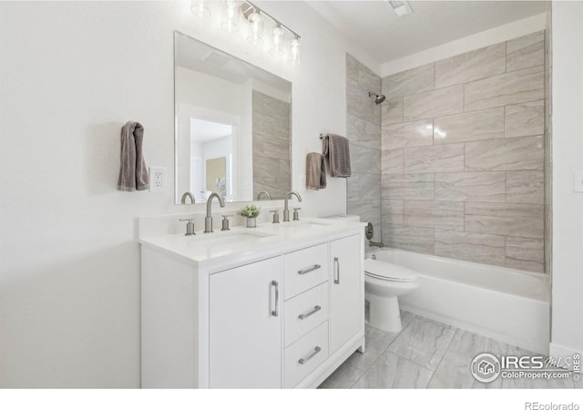 full bathroom with vanity, toilet, and tiled shower / bath