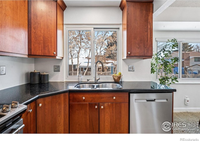 kitchen with sink, dark stone counters, and appliances with stainless steel finishes