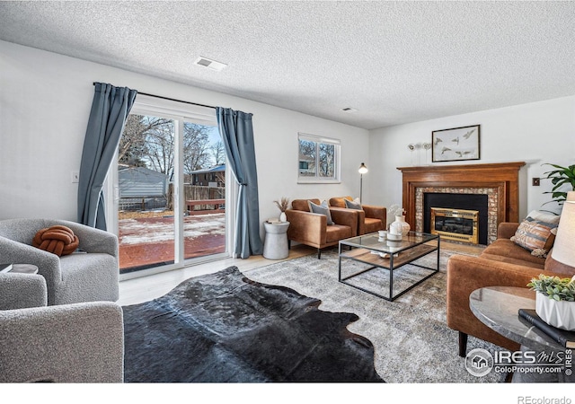 living room featuring a brick fireplace, hardwood / wood-style flooring, and a textured ceiling