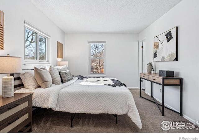 carpeted bedroom featuring multiple windows and a textured ceiling