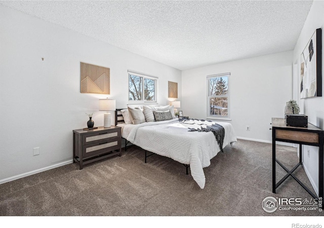 bedroom featuring multiple windows, dark colored carpet, and a textured ceiling