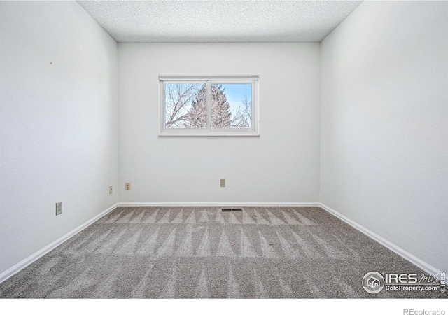 carpeted spare room featuring a textured ceiling