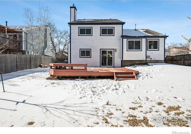 snow covered house featuring a deck