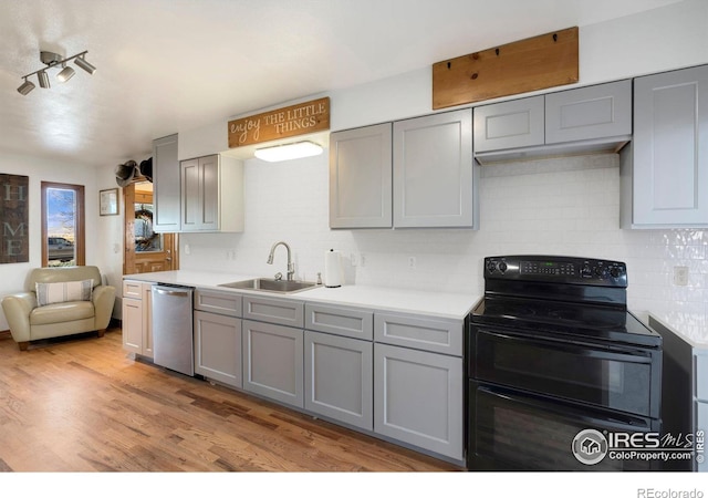 kitchen featuring sink, gray cabinets, dishwasher, double oven range, and light hardwood / wood-style floors