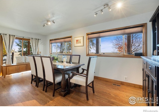 dining room featuring rail lighting and light wood-type flooring