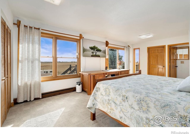 carpeted bedroom featuring a baseboard heating unit