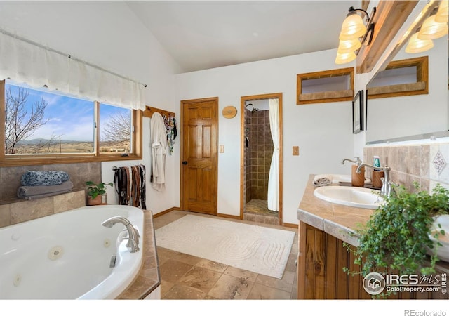 bathroom with lofted ceiling, vanity, and independent shower and bath