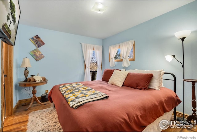 bedroom with access to outside and light wood-type flooring