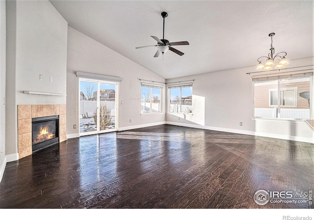 unfurnished living room with a fireplace, high vaulted ceiling, dark hardwood / wood-style flooring, and ceiling fan with notable chandelier