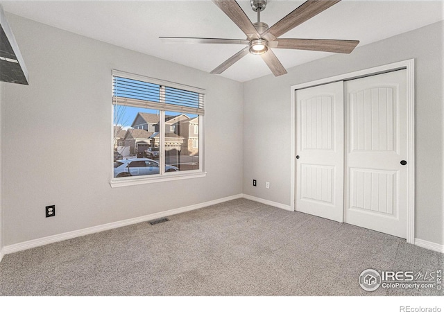 unfurnished bedroom featuring a closet, ceiling fan, and carpet