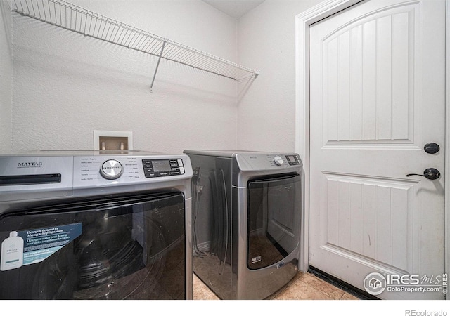 laundry room featuring light tile patterned flooring and washing machine and dryer