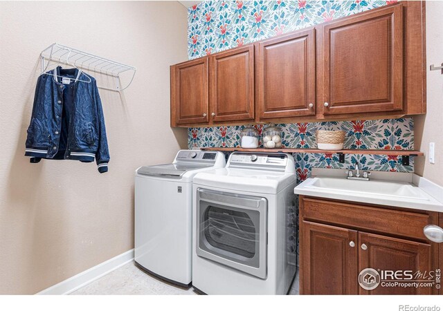 laundry room featuring cabinets, washing machine and dryer, and sink