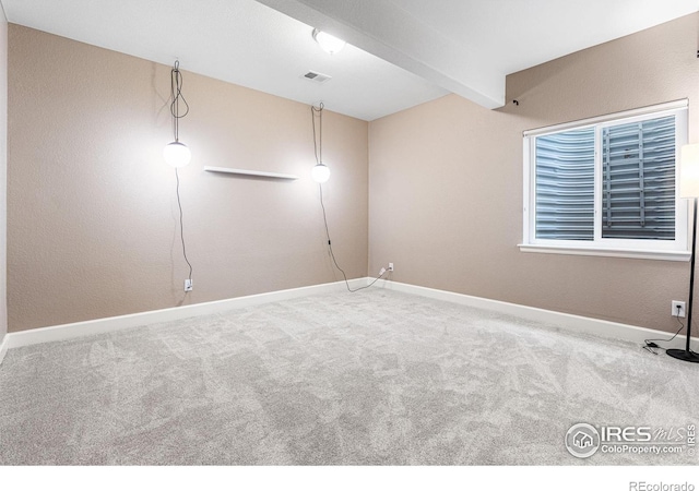 carpeted empty room with beamed ceiling