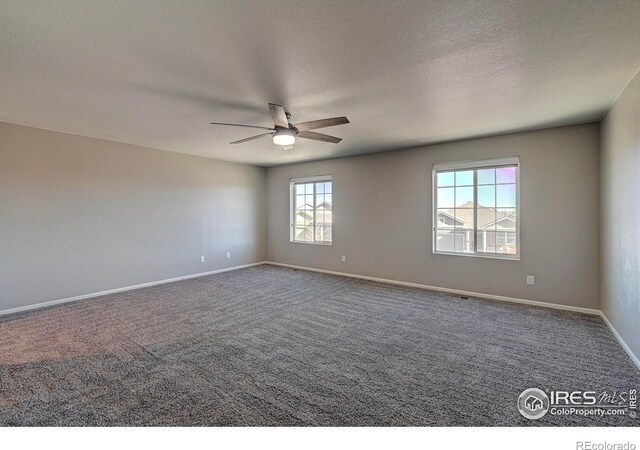 carpeted spare room with ceiling fan and a textured ceiling