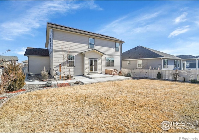 rear view of house with a lawn and a patio