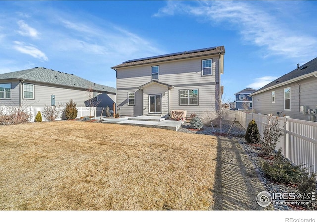 rear view of property featuring a yard and a patio area