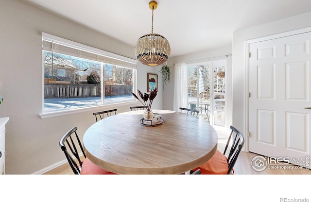 dining area with a chandelier, light hardwood / wood-style flooring, and a wealth of natural light