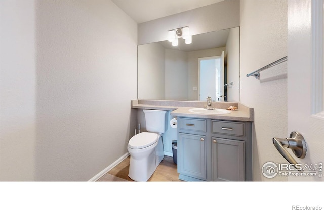 bathroom featuring vanity, hardwood / wood-style flooring, and toilet