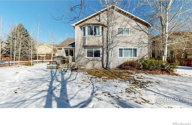 view of snow covered back of property